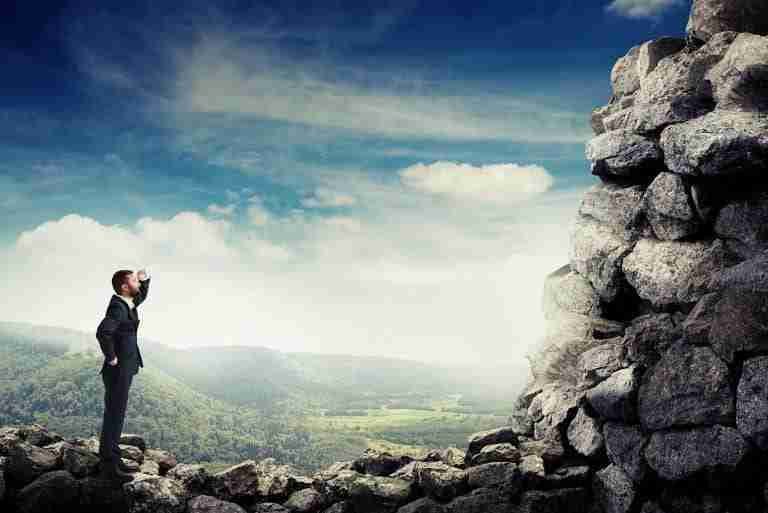 SmileyBusinessmanHoldingHisHandNearBrowAndLookingUp | Professionelles Coaching in Düsseldorf – Bobach Coaching & Consulting Mann mit guter Weitsicht durch Coaching