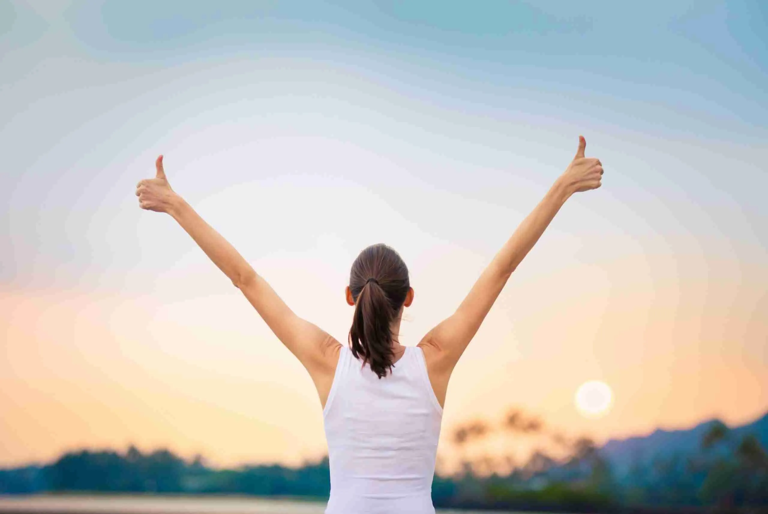 WinningSuccessAndLifeGoalsConceptYoungWomanWithArms Eine Frau die durch Personal Coaching ihr Ziele kennt.