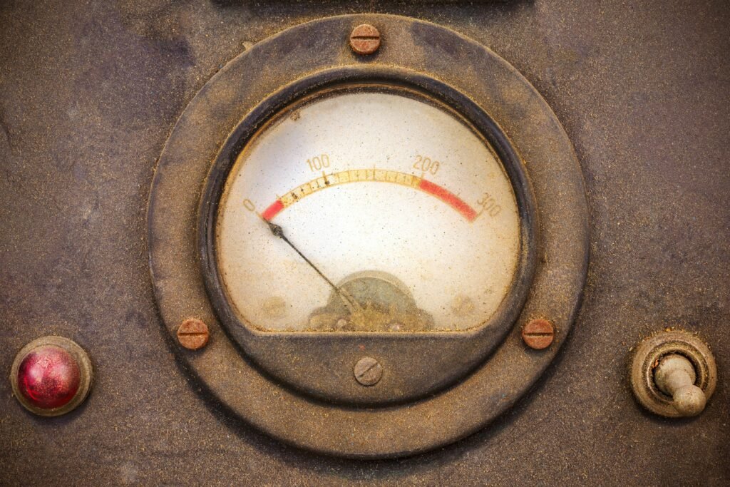 getty-images-esH0ioXIBFI-unsplash | Professionelles Coaching in Düsseldorf – Bobach Coaching & Consulting Close-up of a dusty, circular industrial gauge with a white dial and red markings, showing a needle point near the bottom left.